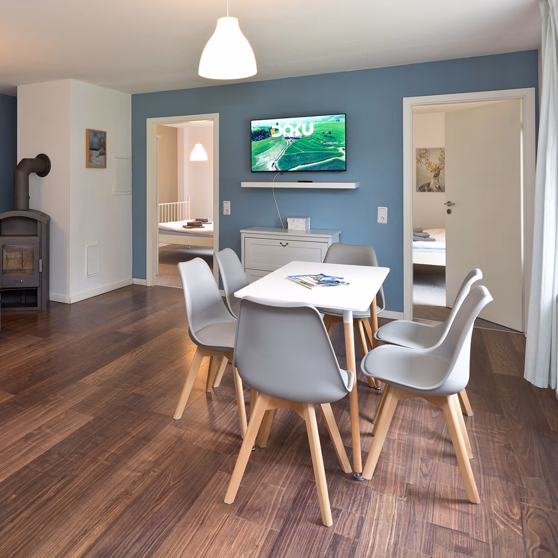 Dining area with dining table and wood-burning stove in a holiday apartment in Jabel